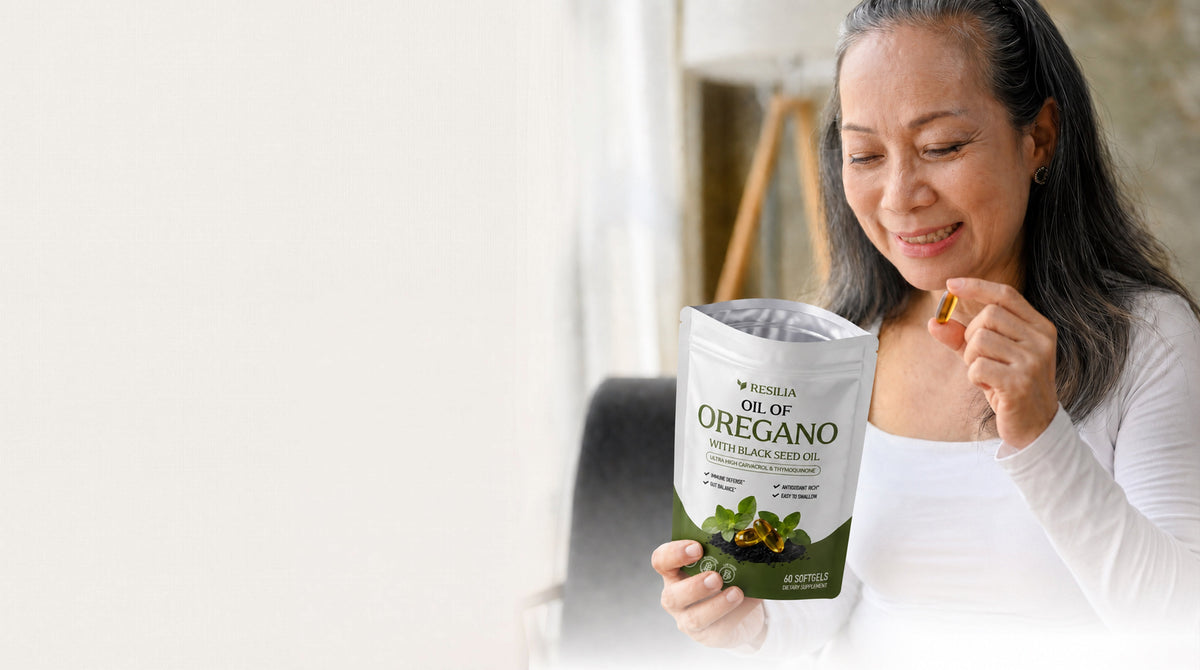 Woman holding a Resilia oregano softgel pouch at home